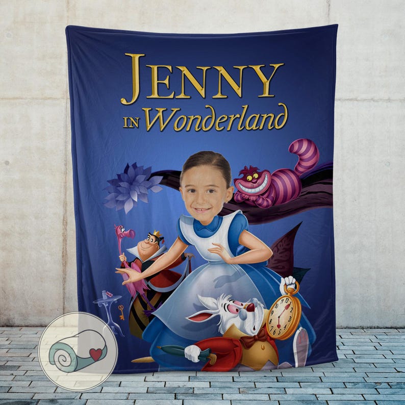 May include: A blue blanket featuring a personalized illustration with the text "JENNY in Wonderland." The design includes cartoon characters from Alice in Wonderland, such as the Cheshire Cat, the White Rabbit, and the Queen of Hearts.