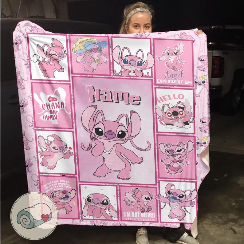 May include: Pink fleece blanket featuring the character Angel from Lilo & Stitch. The blanket has a grid design with various images of Angel, the text "Ohana Means Family", and the word "Name". The blanket is a soft, cozy item.