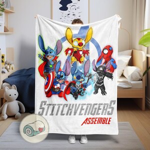 Puede incluir: Manta blanca con personajes de dibujos animados disfrazados de superh&eacute;roes. La manta tiene el texto "Stitchvengers Assemble" en gris y rojo. Los personajes son azules, amarillos, rojos y negros.