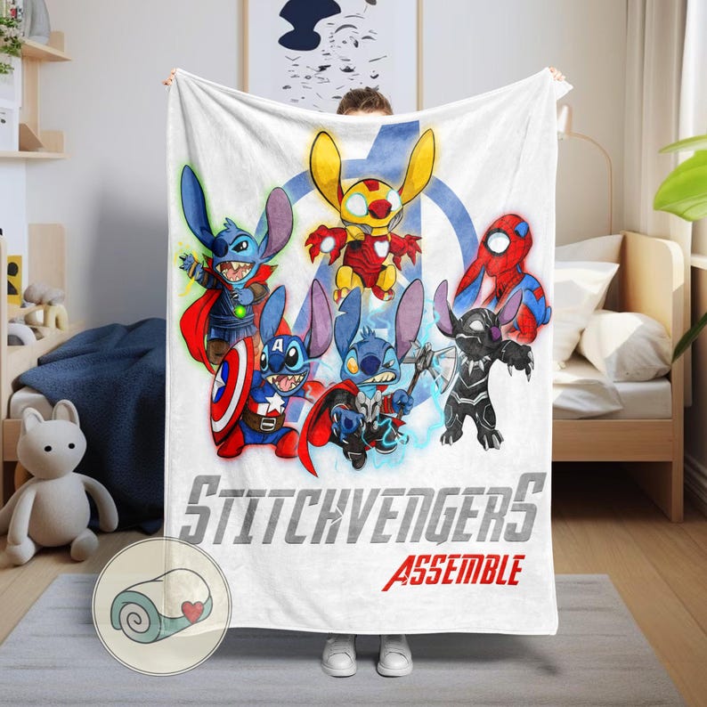 Puede incluir: Manta blanca con personajes de dibujos animados disfrazados de superh&eacute;roes. La manta tiene el texto "Stitchvengers Assemble" en gris y rojo. Los personajes son azules, amarillos, rojos y negros.