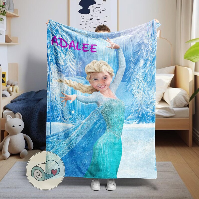 May include: A personalized blue blanket featuring a young girl dressed as Elsa from Frozen, set against a snowy forest backdrop. The name "ADALEE" is printed in pink across the top. The blanket is soft and cozy.