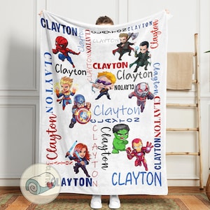 Pu&ograve; includere: Coperta in pile bianca con illustrazioni di supereroi dei cartoni animati e il nome "Clayton" in rosso e blu. La coperta presenta personaggi come Thor e Iron Man, con il nome ripetuto.