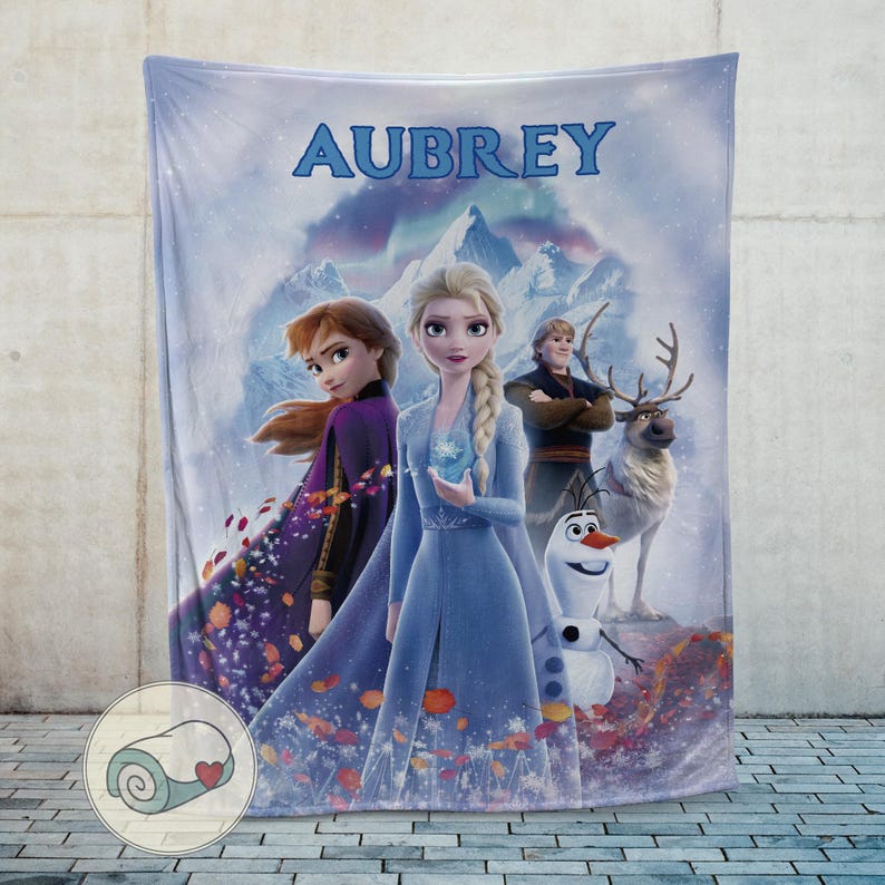 May include: A white ceramic mug with a black handle and the text "But First, Coffee" in a bold, black font. The mug is set against a blurred background, suggesting a cozy setting.