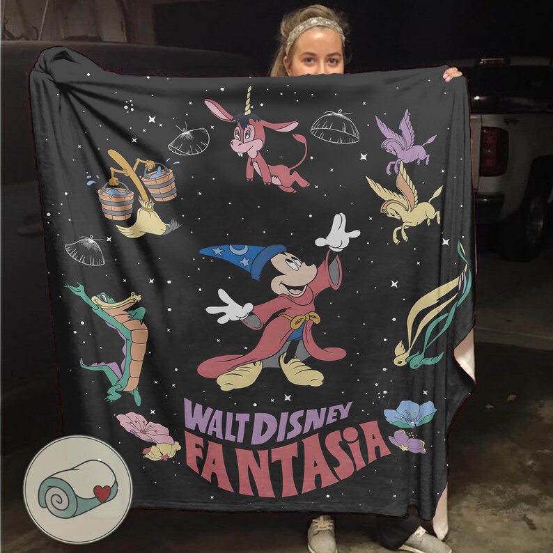 May include: Black blanket with Disney's Fantasia characters. Mickey Mouse as the Sorcerer's Apprentice is featured, alongside other characters and the film's title in a colourful, stylised font. A cosy home decor item, perfect for snuggling up with.