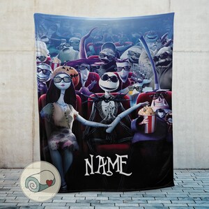 Puede incluir: Una manta azul que representa una escena de cine con personajes de Pesadilla antes de Navidad. Jack Skellington y Sally est&aacute;n en la primera fila. La palabra "NAME" est&aacute; escrita en blanco.