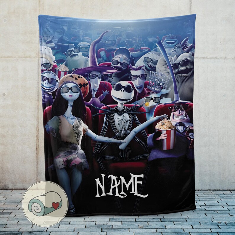 Puede incluir: Una manta azul que representa una escena de cine con personajes de Pesadilla antes de Navidad. Jack Skellington y Sally est&aacute;n en la primera fila. La palabra "NAME" est&aacute; escrita en blanco.