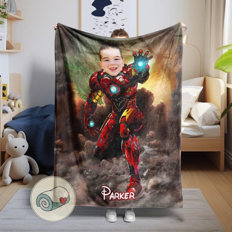 May include: A personalized blanket featuring a child's face superimposed on an Iron Man illustration. The blanket is predominantly red and gold, with a name, "Parker," printed at the bottom. The background has a cloudy, smoky effect.