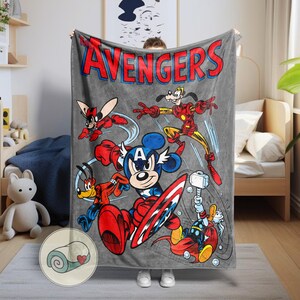 May include: A gray Avengers fleece blanket featuring Mickey Mouse as Captain America, Goofy as Iron Man, and other Disney characters in superhero poses. The word "AVENGERS" is in red and blue letters at the top.