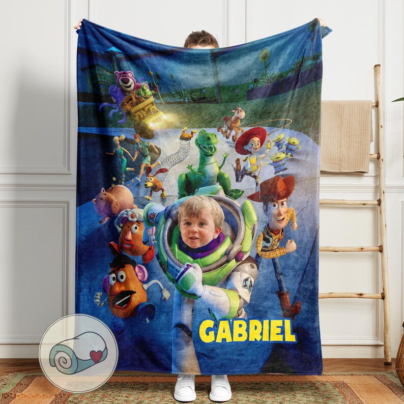 May include: A blue fleece blanket featuring a collage of characters from the animated film Toy Story, including Buzz Lightyear, Woody, and Rex. The blanket has a personalized touch with the name "GABRIEL" in yellow block letters.