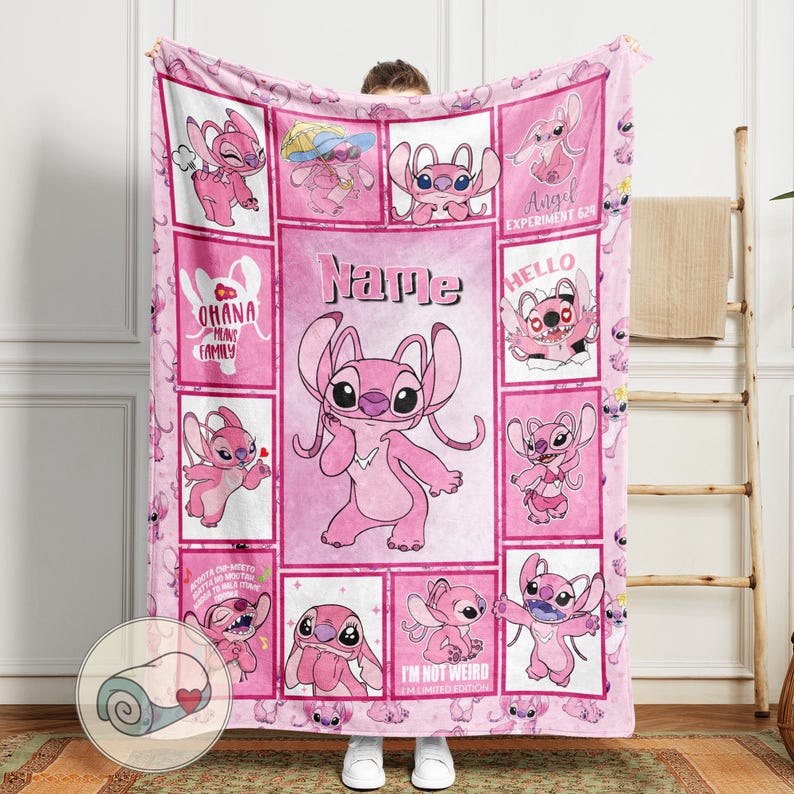 May include: A pink fleece blanket featuring a collage of images of the character Angel from Lilo & Stitch. The blanket has a grid pattern with various poses of Angel, along with the text "Name", "Ohana means family", and "I'm not weird I'm limited edition".