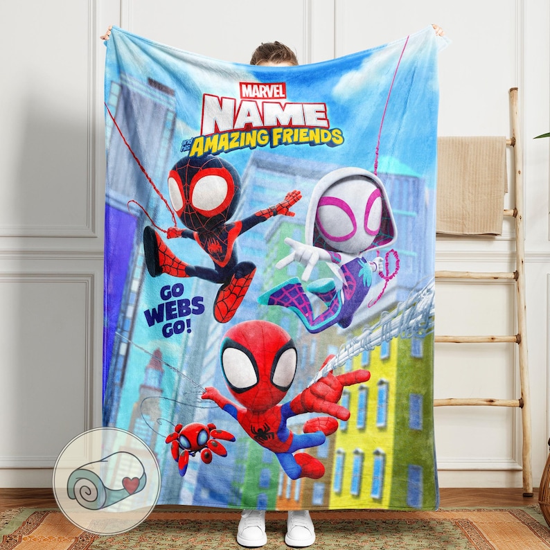 May include: A blue Marvel blanket featuring Spider-Man characters. The blanket has the text "Marvel Name Amazing Friends" and "Go Webs Go!". The blanket features illustrations of Spider-Man, Miles Morales, and Spider-Gwen.