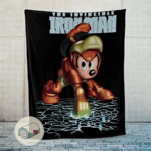 May include: Black blanket featuring Mickey Mouse in an Iron Man suit, with the text "THE INVINCIBLE IRON MAN" in blue and white. The blanket has a cracked ground design and a cartoon style.