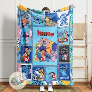 May include: A colorful throw blanket featuring cartoon characters and text. The blanket has a blue background with various squares displaying images of Stitch and Lilo. Text includes "Name", "Ohana", and "Stay Weird".