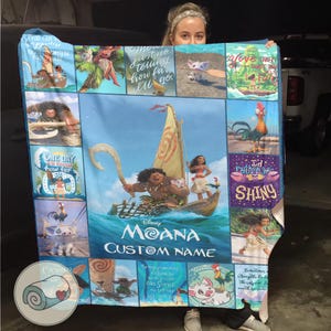 Może przedstawiać: Niebieski koc z motywem Moany przedstawiający r&oacute;żne postacie i sceny z filmu. Koc ma centralny obraz Moany, Mauiego i łodzi, z tekstem "Moana Custom Name". Otaczające obrazy obejmują postacie i cytaty.