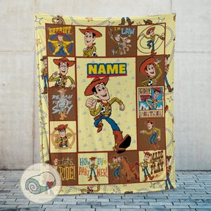 May include: A yellow blanket featuring a collage of images of a cartoon cowboy character. The blanket has a repeating pattern of the character in various poses, with the word "NAME" in the center.