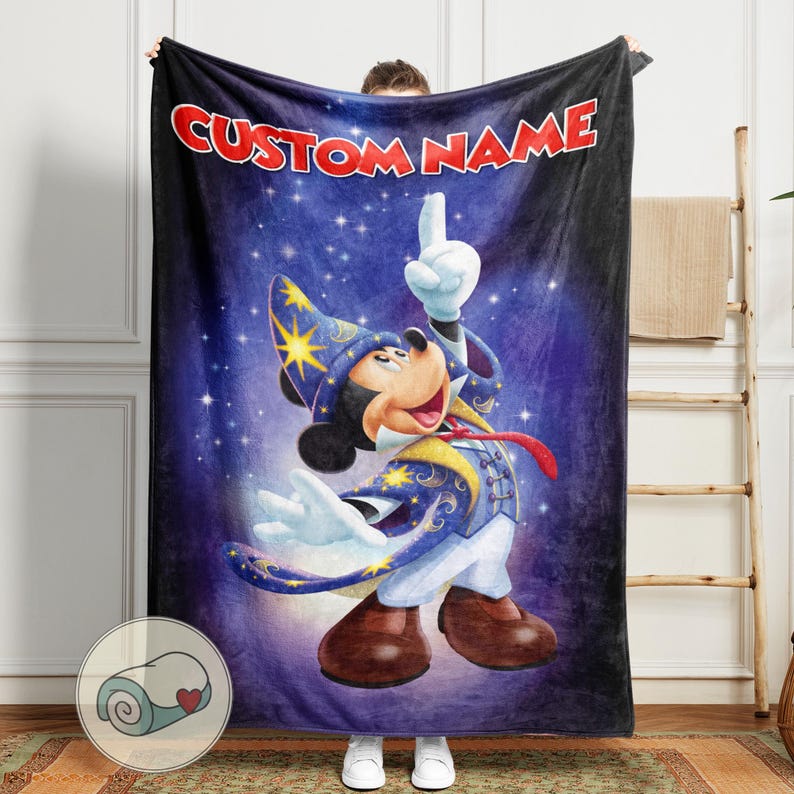 Op de afbeelding: Een zachte deken met een cartoonafbeelding van Mickey Mouse als tovenaar op een sterrenblauwe achtergrond. De tekst "CUSTOM NAME" staat in het rood. Deze deken is ontworpen voor comfort en warmte.