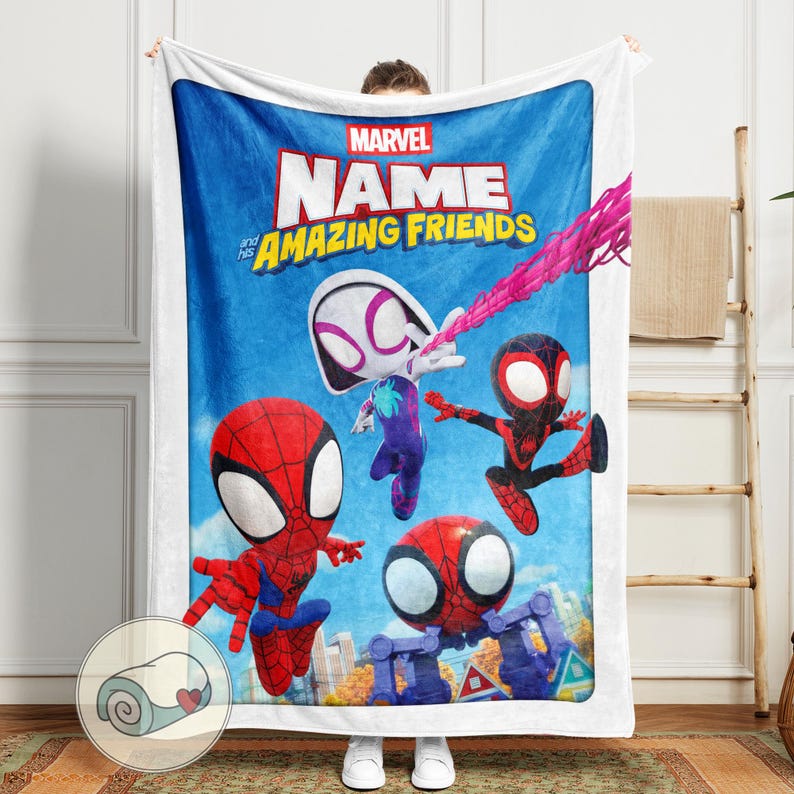 May include: A white blanket featuring a vibrant illustration of Spider-Man and his Amazing Friends. The blanket has a blue background with the Marvel logo and the text "NAME and his AMAZING FRIENDS". The characters are in action poses.
