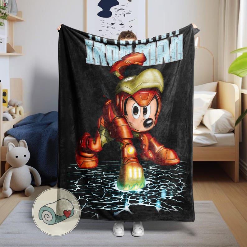 May include: Black blanket featuring a cartoon character in an Iron Man suit. The character is red and gold, with a yellow helmet. The blanket has the words "IRON MAN" in light blue across the top. The character is posed on a cracked, electric blue surface.