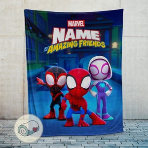 Pu&ograve; includere: Una coperta blu Marvel con tre personaggi dei cartoni animati: Spider-Man, Miles Morales e Spider-Gwen. La coperta presenta il logo Marvel e le parole "Name and his Amazing Friends". I personaggi sono ambientati su uno sfondo di paesaggio urbano.