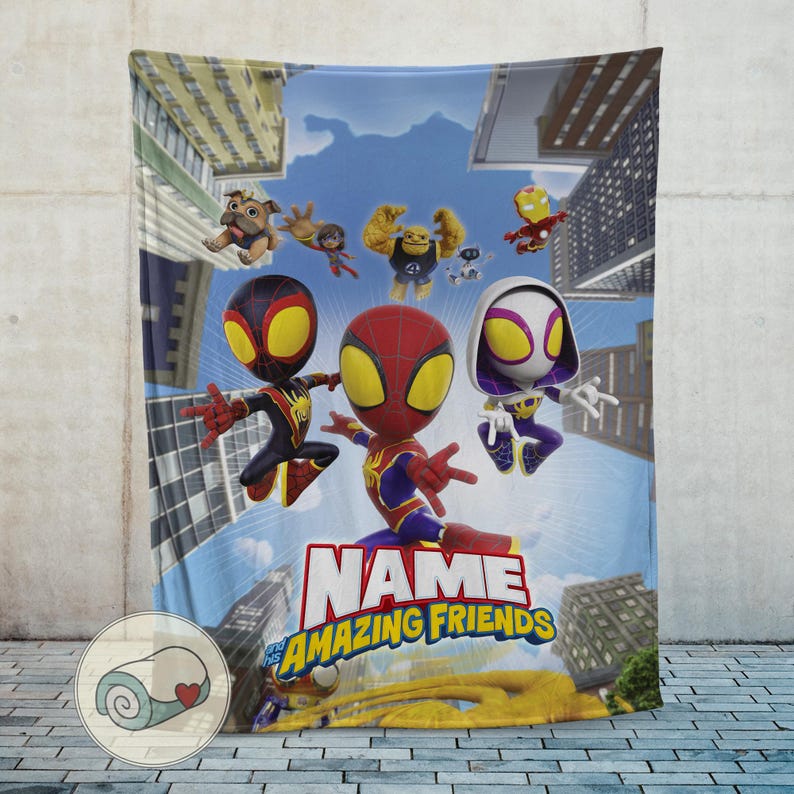May include: A colorful blanket featuring cartoon characters, including Spider-Man and other heroes, against a cityscape backdrop. The blanket has the text "NAME Amazing Friends" in large letters. The blanket is made of soft material.