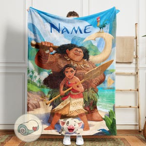 May include: A blue blanket featuring characters from the animated film Moana, with the word "Name" in large blue letters. The blanket depicts Maui, Moana, and Hei Hei the rooster. A rolled-up blanket with a heart is shown in a circle.