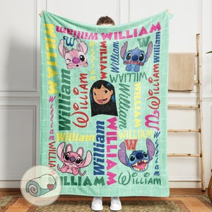 May include: A mint green blanket featuring cartoon characters and the name "William" in various colors and fonts. The blanket has a grid pattern and includes images of a girl and two alien creatures.