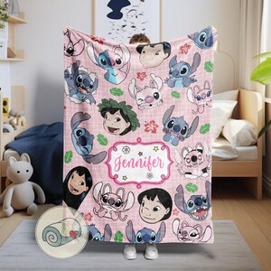 May include: Pink fleece blanket featuring cartoon characters and the name "Jennifer" in a decorative frame. The blanket showcases various images of the characters in different poses, with a repeating pattern of flowers and leaves. The blanket is a soft, cozy item.