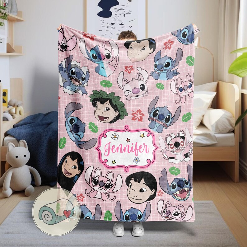 May include: Pink fleece blanket featuring cartoon characters and the name "Jennifer" in a decorative frame. The blanket showcases various images of the characters in different poses, with a repeating pattern of flowers and leaves. The blanket is a soft, cozy item.
