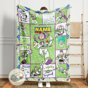 May include: A green and purple blanket featuring Buzz Lightyear from Toy Story. The blanket has a grid design with various images of Buzz, along with phrases like "You've got a friend in me" and "to infinity and beyond!"