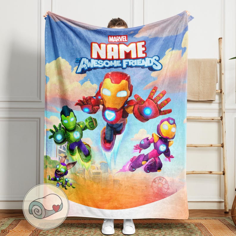 K&ouml;nnte beinhalten: Eine Marvel-Decke mit Iron Man und anderen Charakteren vor blauem Himmel. Die Decke zeigt die Worte "NAME" und "Awesome Friends". Die Decke wird von einer Person gehalten.