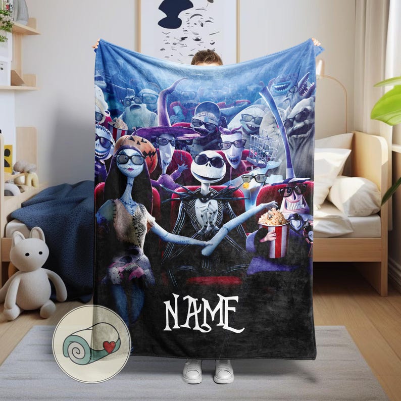 Puede incluir: Una manta de forro polar azul con personajes de Pesadilla antes de Navidad en un cine. La manta tiene un borde negro y la palabra "NAME" en escritura blanca. Los personajes llevan gafas 3D.