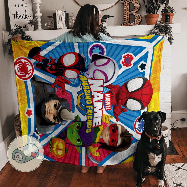 May include: A colorful Marvel Amazing Friends blanket featuring Spider-Man, Spider-Gwen, and other characters. The blanket has a blue and yellow geometric design with the Marvel logo. A black dog sits in front of the blanket.