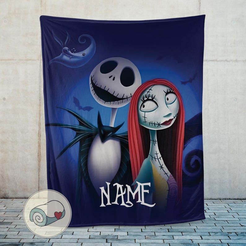 May include: A dark blue throw blanket featuring Jack Skellington and Sally from The Nightmare Before Christmas. The blanket has a cartoon illustration of the characters with the word "NAME" in white script. A crescent moon and bats are in the background.