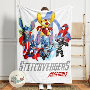 Puede incluir: Manta blanca con un dise&ntilde;o gr&aacute;fico de personajes Stitch vestidos como superh&eacute;roes de los Vengadores. La manta tiene las palabras "Stitchvengers Assemble". Los personajes incluyen a Iron Man, Capit&aacute;n Am&eacute;rica, Thor y Spider-Man.