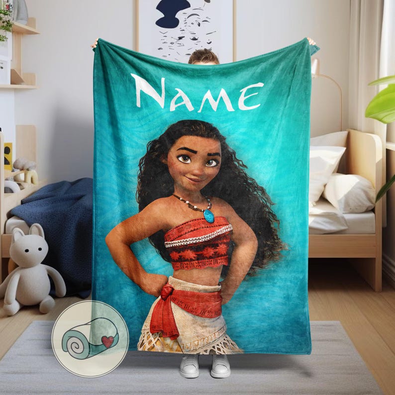 K&ouml;nnte beinhalten: Eine t&uuml;rkisfarbene Decke mit einer Cartoon-Illustration einer Frau mit langen, dunklen Locken, die ein rot-wei&szlig;es Outfit und eine Halskette mit einem blauen Anh&auml;nger tr&auml;gt. Das Wort "Name" steht in Wei&szlig; oben auf der Decke.