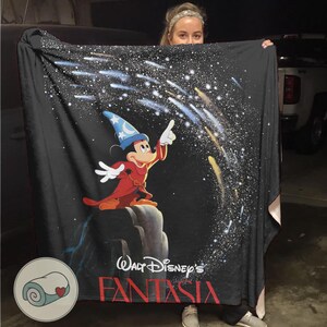 Peut inclure: Couverture noire avec Mickey Mouse en apprenti sorcier de Fantasia de Disney. Mickey porte un chapeau bleu et une robe rouge, pointant vers un ciel &eacute;toil&eacute;. La couverture porte les mots "Walt Disney's Fantasia" en rouge.