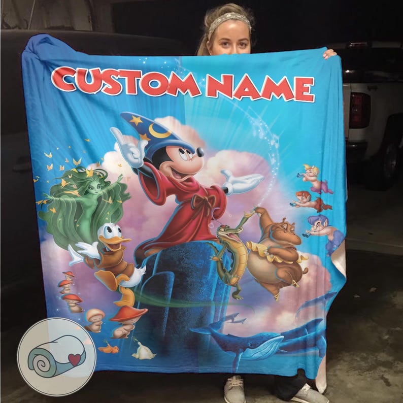 May include: A blue blanket featuring a colorful illustration of Mickey Mouse as a wizard, with other Disney characters. The blanket has the text "CUSTOM NAME" in red letters at the top. The blanket is held up by a person.