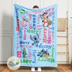 K&ouml;nnte beinhalten: Eine hellblaue Decke mit Cartoon-Figuren und dem Namen "Harry" in verschiedenen Farben. Die Decke hat ein Gittermuster und zeigt Bilder von Stitch und Lilo & Stitch-Charakteren. Die Decke ist unten links aufgerollt.