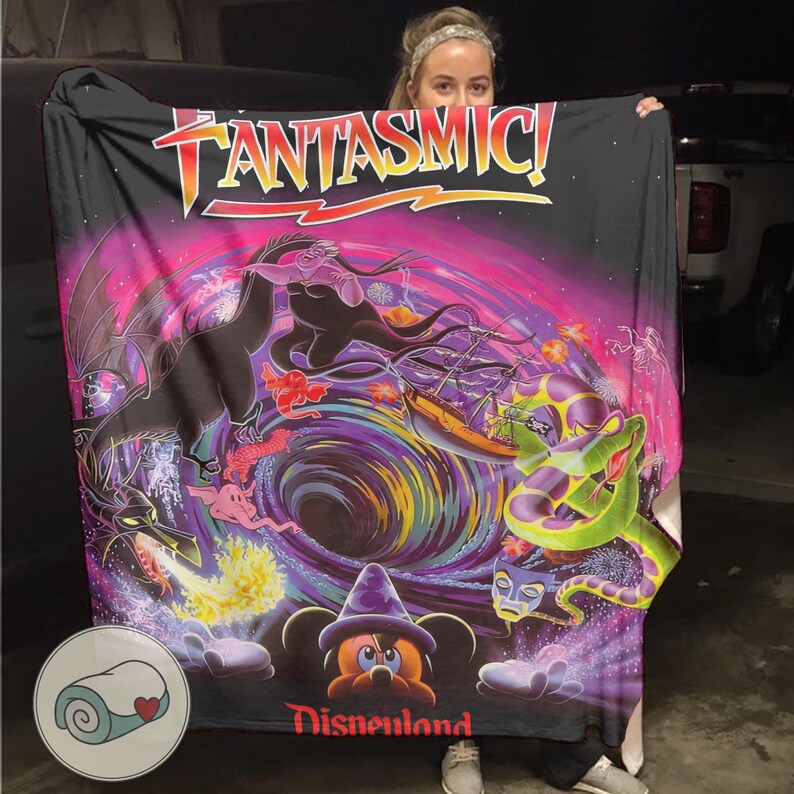May include: Black blanket featuring a colorful Fantasmic! design with characters and the Disneyland logo. The blanket has a vibrant, swirling background with images of a dragon, Ursula, and Mickey Mouse.