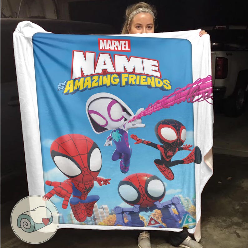 May include: A blue blanket featuring the Marvel logo and the words "NAME and his AMAZING FRIENDS." The blanket showcases cartoon illustrations of Spider-Man characters in action poses. The blanket is held up by a person.