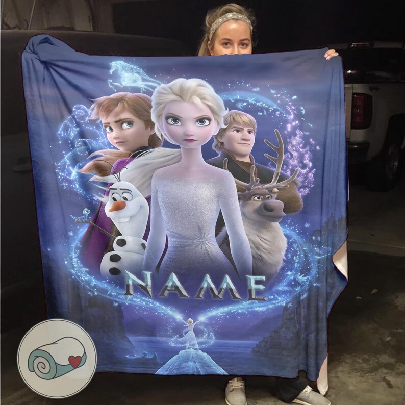 Pu&ograve; includere: Una coperta blu con i personaggi del film d'animazione Frozen. La coperta mostra Elsa, Anna, Kristoff, Olaf e Sven, circondati da un design blu e bianco. La parola "NAME" &egrave; stampata a grandi lettere.