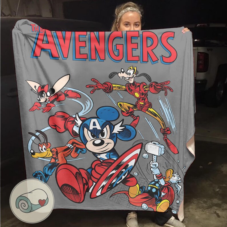 May include: A gray blanket featuring a comic-style design of Disney characters as Avengers. The word "AVENGERS" is in red and blue. Mickey Mouse is Captain America, and Goofy is Iron Man. Other characters include Minnie Mouse and Donald Duck.