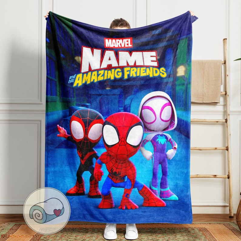 Pu&ograve; includere: Una coperta blu Marvel con la scritta "NAME and his AMAZING FRIENDS" e immagini dei cartoni animati di Spider-Man, Miles Morales e Spider-Gwen. La coperta ha un'immagine arrotolata nell'angolo in basso a sinistra.