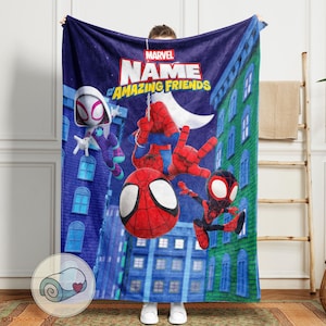 May include: A blue Marvel blanket featuring Spider-Man and friends. The blanket has a cityscape background and the words "Marvel Name of Amazing Friends". The design includes Spider-Man, Spider-Gwen, and Miles Morales.
