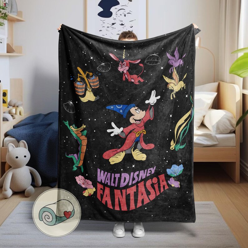 May include: Black blanket with characters and text from Walt Disney's Fantasia. The design includes Mickey Mouse in a sorcerer's outfit, along with other animated figures and the film's title in red and purple lettering. The blanket is held up by a person.