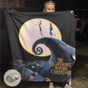 K&ouml;nnte beinhalten: Schwarze Decke mit einer Szene aus "The Nightmare Before Christmas". Das Design zeigt Jack und Sally vor einem Vollmond, mit dem Filmtitel in goldfarbenen Buchstaben. K&uuml;rbisse und ein wirbelnder H&uuml;gel vervollst&auml;ndigen das gruselige Thema.