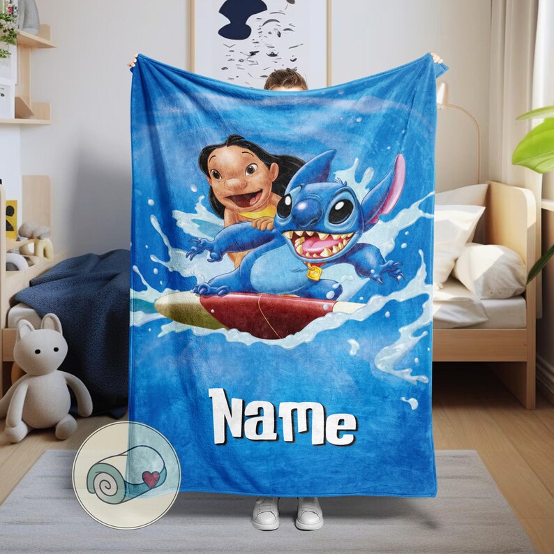 May include: Blue fleece blanket featuring Stitch and Lilo surfing on a wave. The blanket has a personalized "Name" text in white. The design includes water splashes and a rolled-up blanket graphic in the corner.