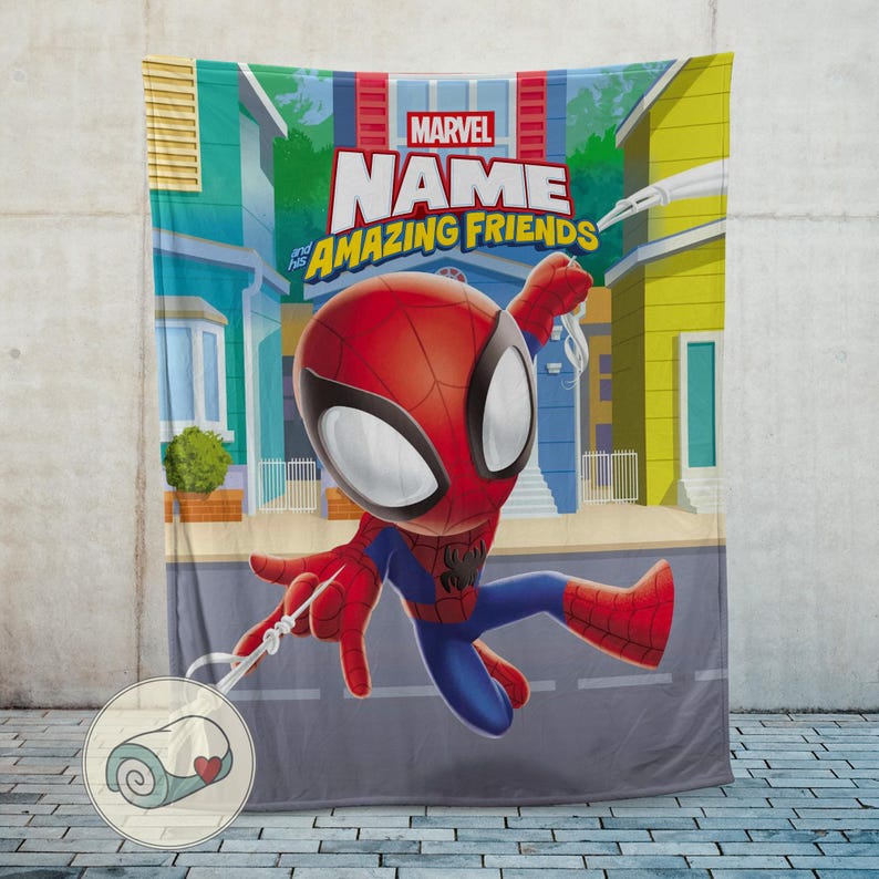 May include: A Marvel Spider-Man blanket featuring a cartoon Spider-Man character in a dynamic pose. The blanket has a cityscape backdrop with the words "Marvel" and "Amazing Friends" printed on it. The blanket is displayed against a gray wall.