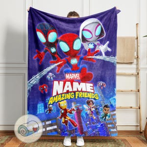 May include: A plush, purple Marvel blanket featuring Spider-Man, Spider-Gwen, and Miles Morales. The blanket has the text "Marvel Name Amazing Friends" and includes other Marvel characters. The blanket is rolled up in a circular image.