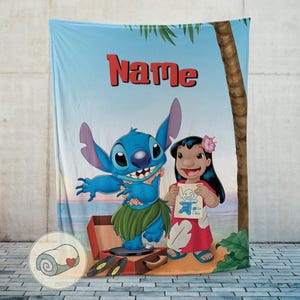 May include: A blue blanket featuring the characters Stitch and Lilo from the animated movie Lilo & Stitch. The blanket has a beach scene background with a palm tree and the word "Name" in red. Stitch is wearing a grass skirt, and Lilo is holding a drawing.
